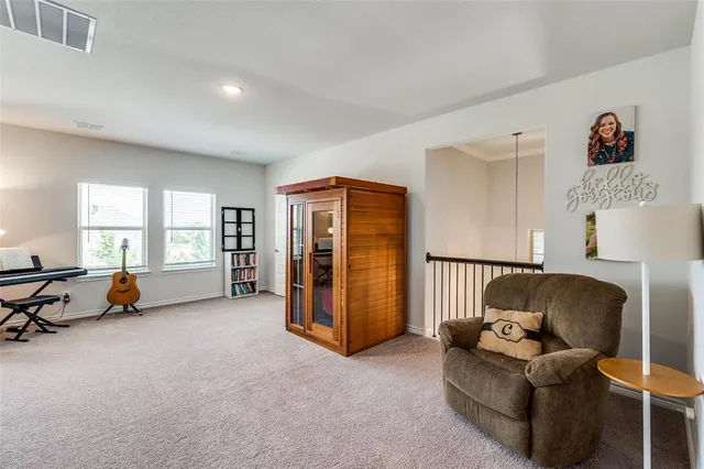 a spacious bedroom with a large bed chandelier and a window