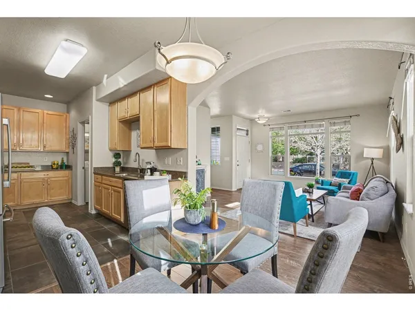 a living room with furniture a large window and kitchen view