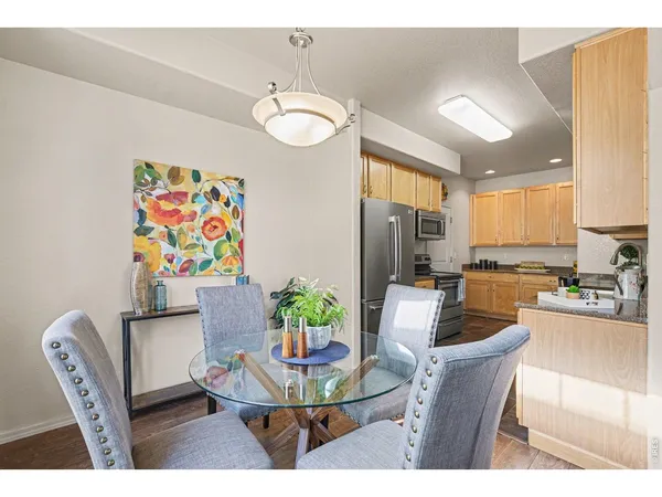 a dining room with furniture a kitchen view and wooden floor