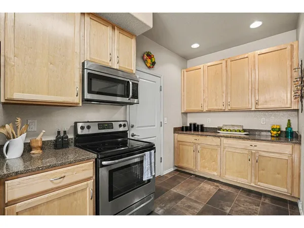 a kitchen with stainless steel appliances granite countertop a stove a sink and a microwave