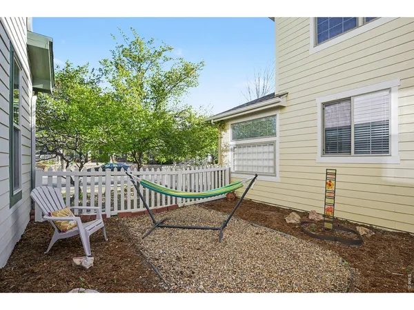 a view of a chair and table in backyard of the house