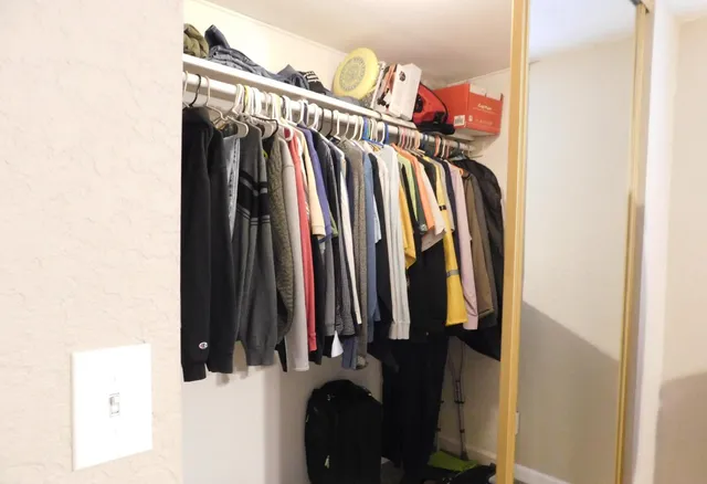 a view of walk in closet with clothes and shoes