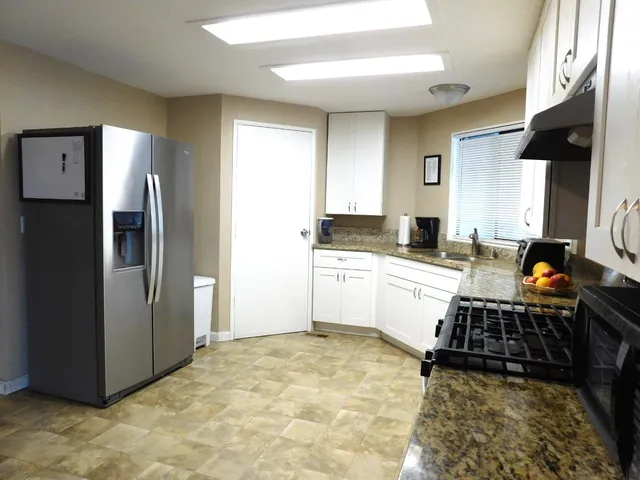 a kitchen with stainless steel appliances a refrigerator sink and stove