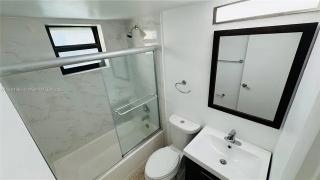 a bathroom with a toilet a sink and mirror