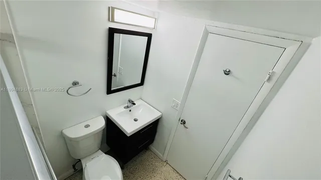 a bathroom with a toilet sink and mirror