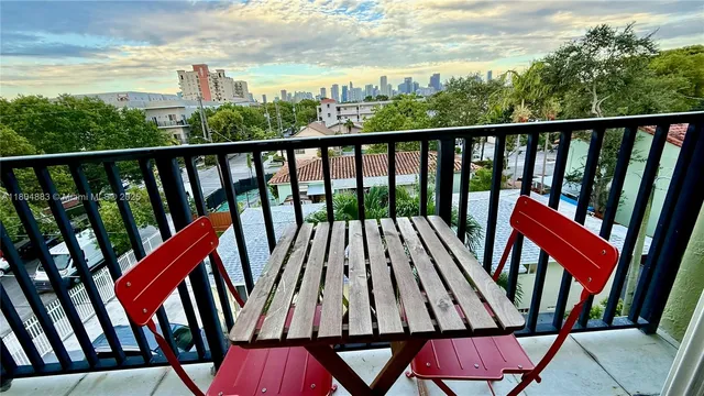 a view of a balcony with wooden floor and outdoor seating