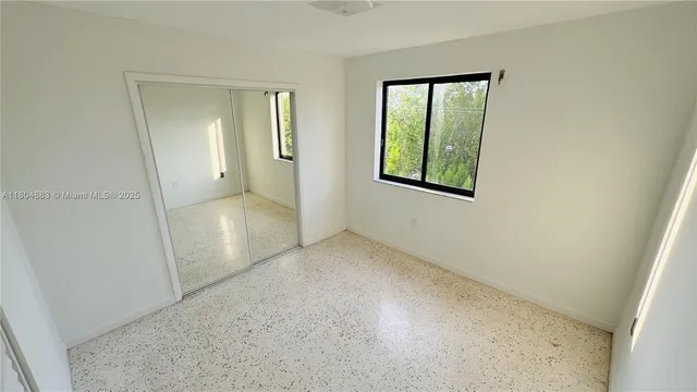 an empty room with windows and closet