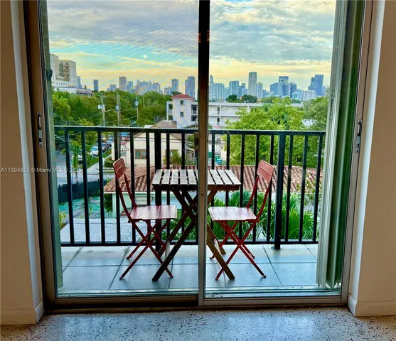 a view of a balcony with chairs and wooden floor