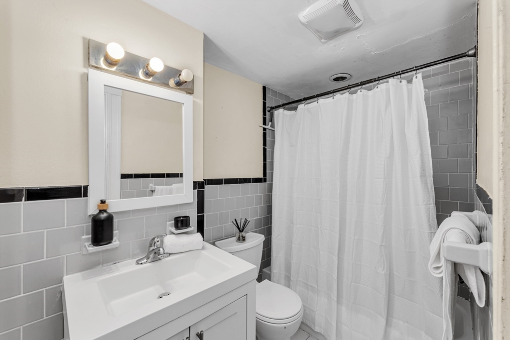 48 Robinwood Avenue, Unit W2 Boston, MA 02130 - Photo 9 of 12 a bathroom with a sink a toilet and shower curtain