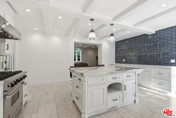 a kitchen with stainless steel appliances kitchen island granite countertop a stove a sink and a refrigerator
