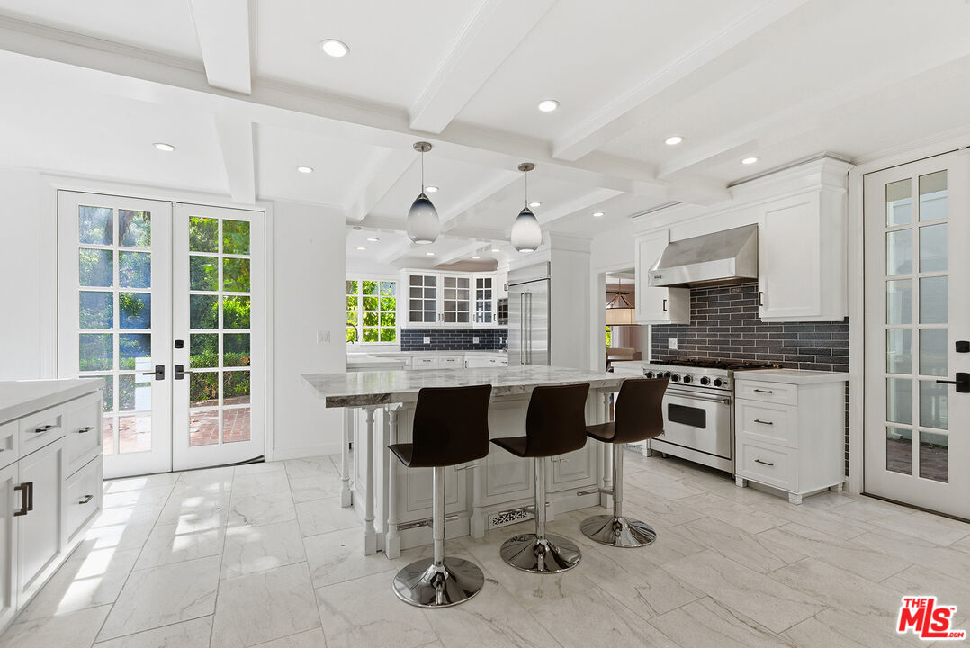 9305 Hazen Drive Beverly Hills, CA 90210 - Photo 25 of 59 a kitchen with stainless steel appliances kitchen island granite countertop a stove a sink and a refrigerator
