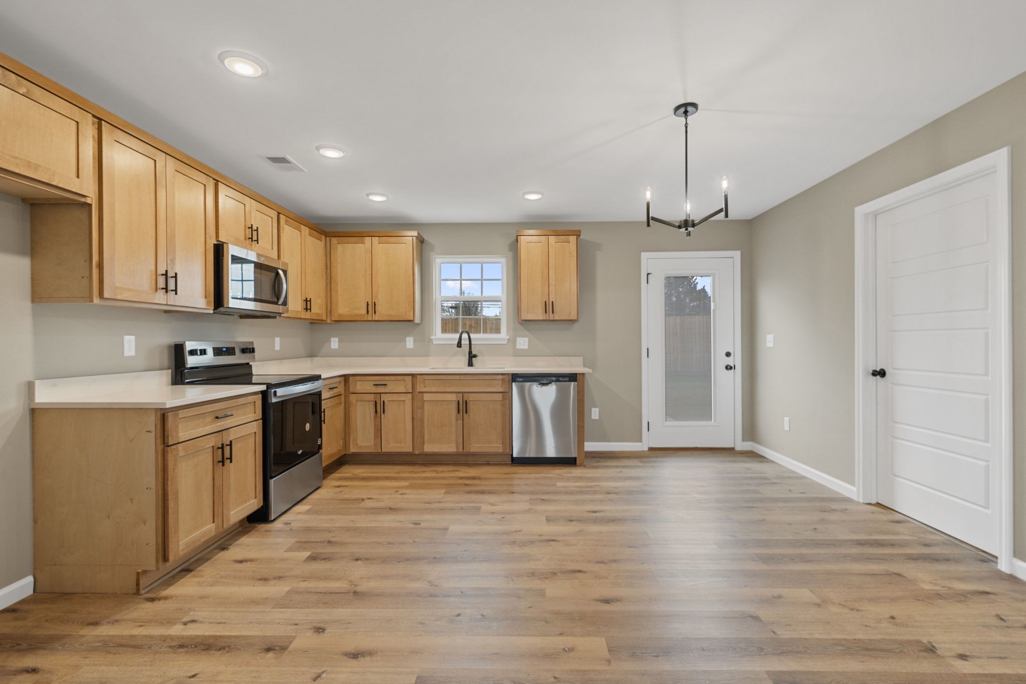 1105 Brook Court Franklin, KY 42134 - Photo 7 of 27 a large kitchen with stainless steel appliances granite countertop a stove a sink dishwasher a refrigerator white cabinets and wooden floor