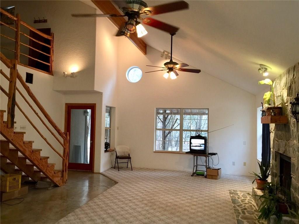 1850 North Rainbow Ranch Road Wimberley, TX 78676 - Photo 2 of 26 an empty room with windows and ceiling fan
