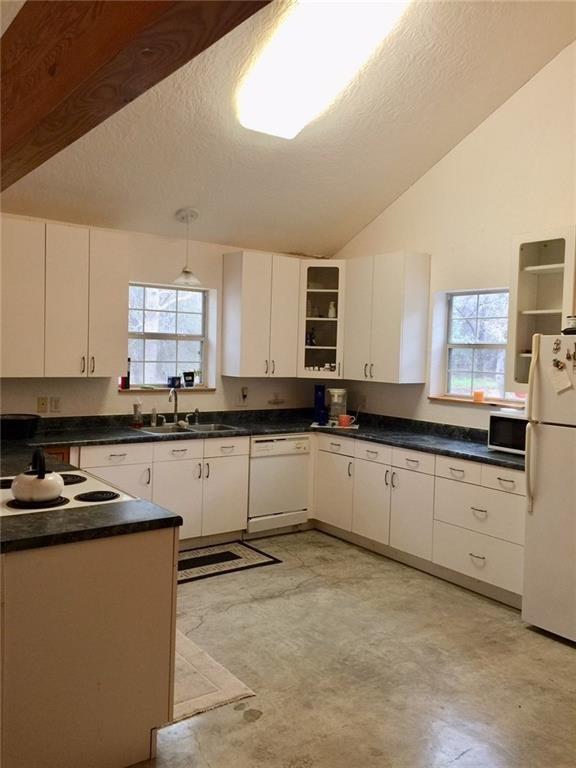 1850 North Rainbow Ranch Road Wimberley, TX 78676 - Photo 5 of 26 a kitchen with granite countertop a sink a stove a microwave a counter top space and cabinets