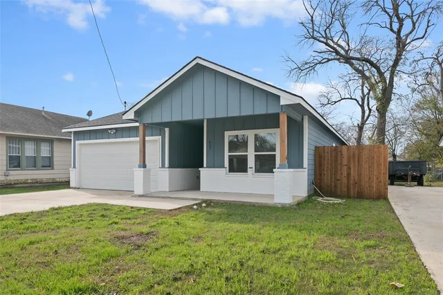a front view of house with yard and garage