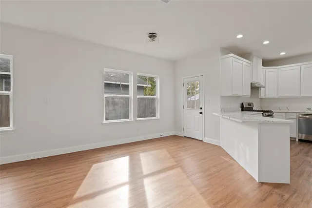 a kitchen with granite countertop white cabinets and window