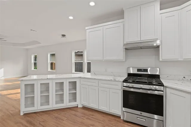 a kitchen with white cabinets and appliances