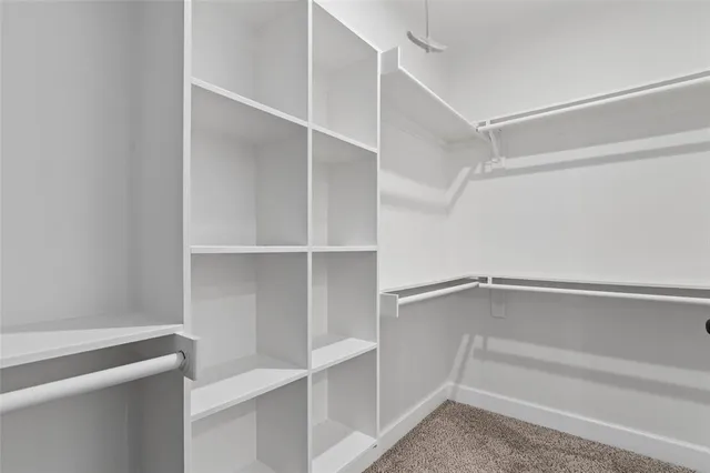 a view of walk in closet with empty racks