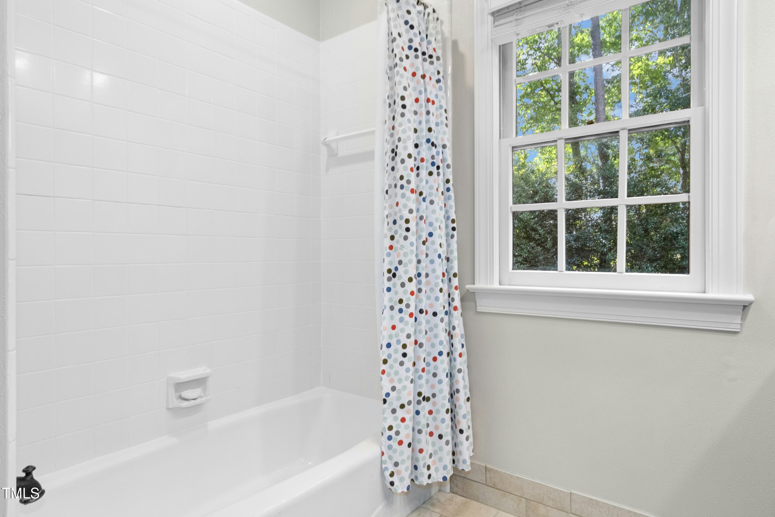 12317 Lockhart Lane Raleigh, NC 27614 - Photo 31 of 38 a bathroom with a bathtub and window