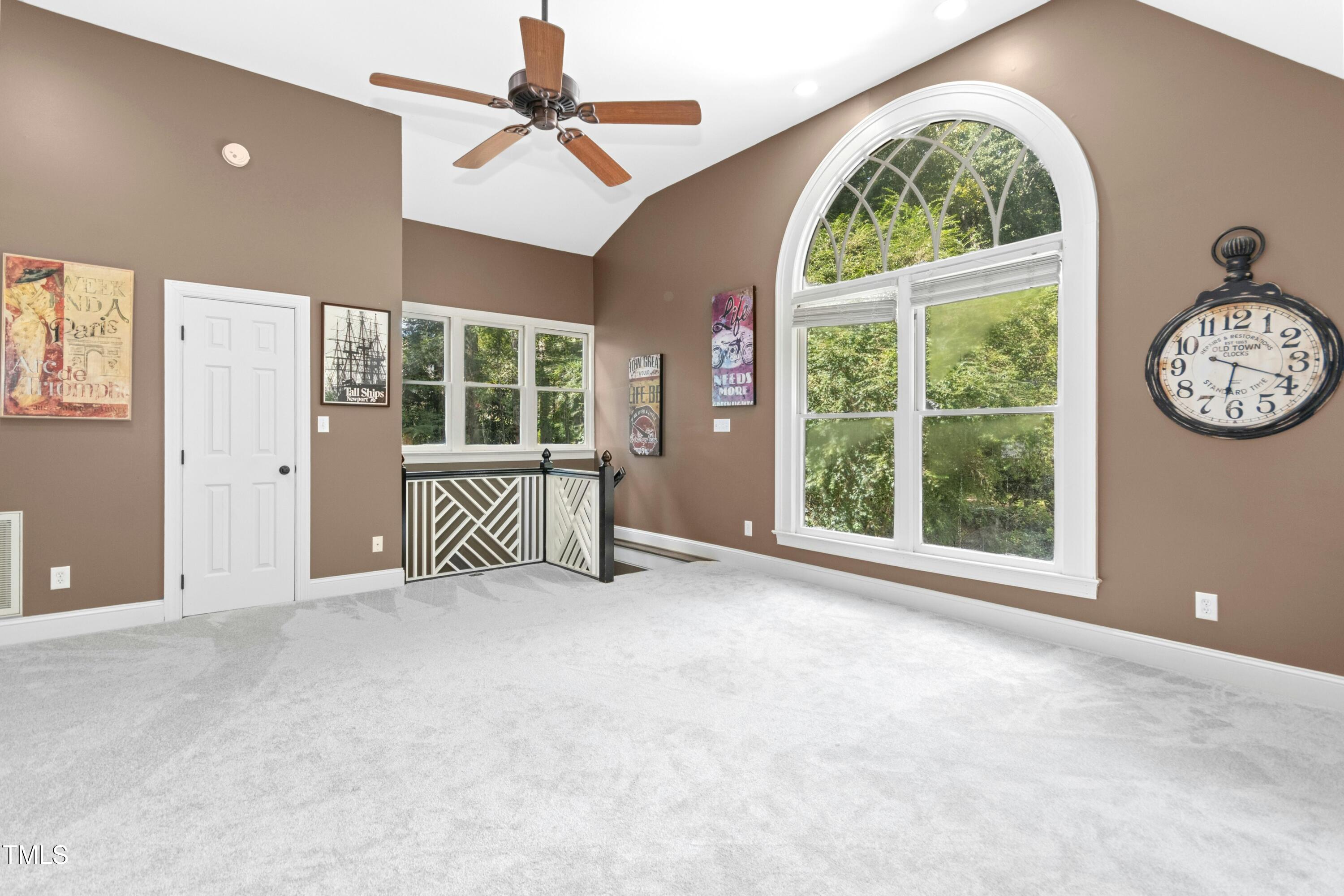 12317 Lockhart Lane Raleigh, NC 27614 - Photo 33 of 38 an empty room with large windows and a chandelier