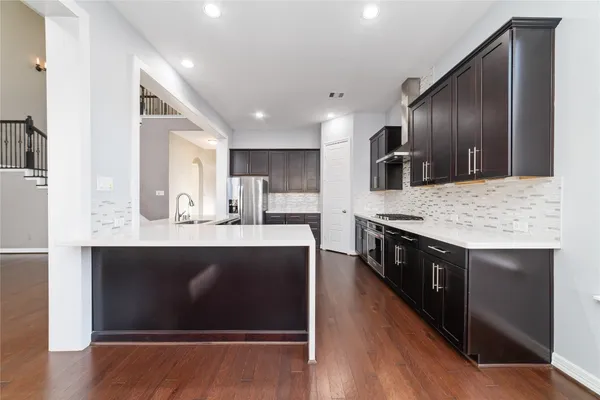 a kitchen with stainless steel appliances granite countertop wooden cabinets and sink