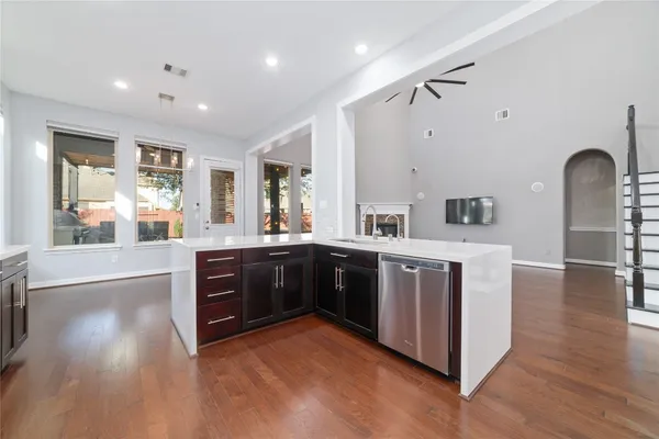 a large kitchen with stainless steel appliances granite countertop a large counter top and a wooden floors