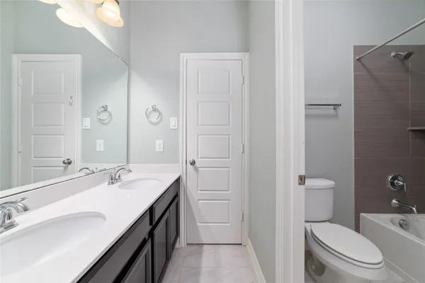 a spacious bathroom with a granite countertop sink a toilet and a mirror