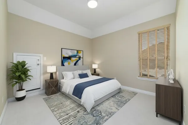 a bedroom with a large bed and a potted plant