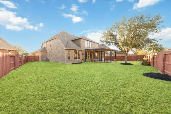 a view of a house with a big yard plants and large trees