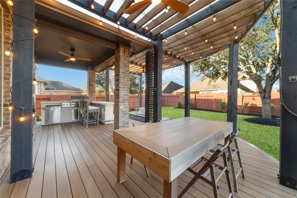 a view of a patio with table and chairs and floor to ceiling window with wooden floor