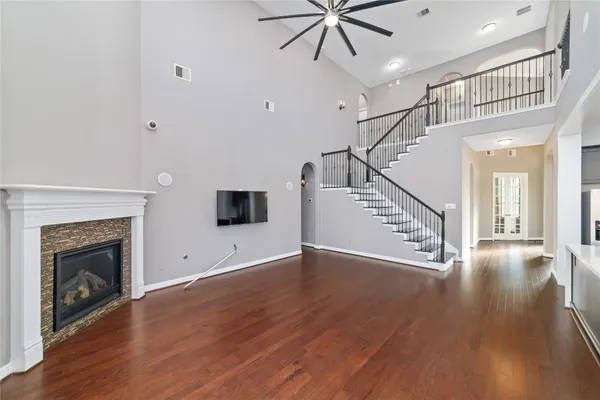 a view of an empty room with wooden floor fireplace and a window