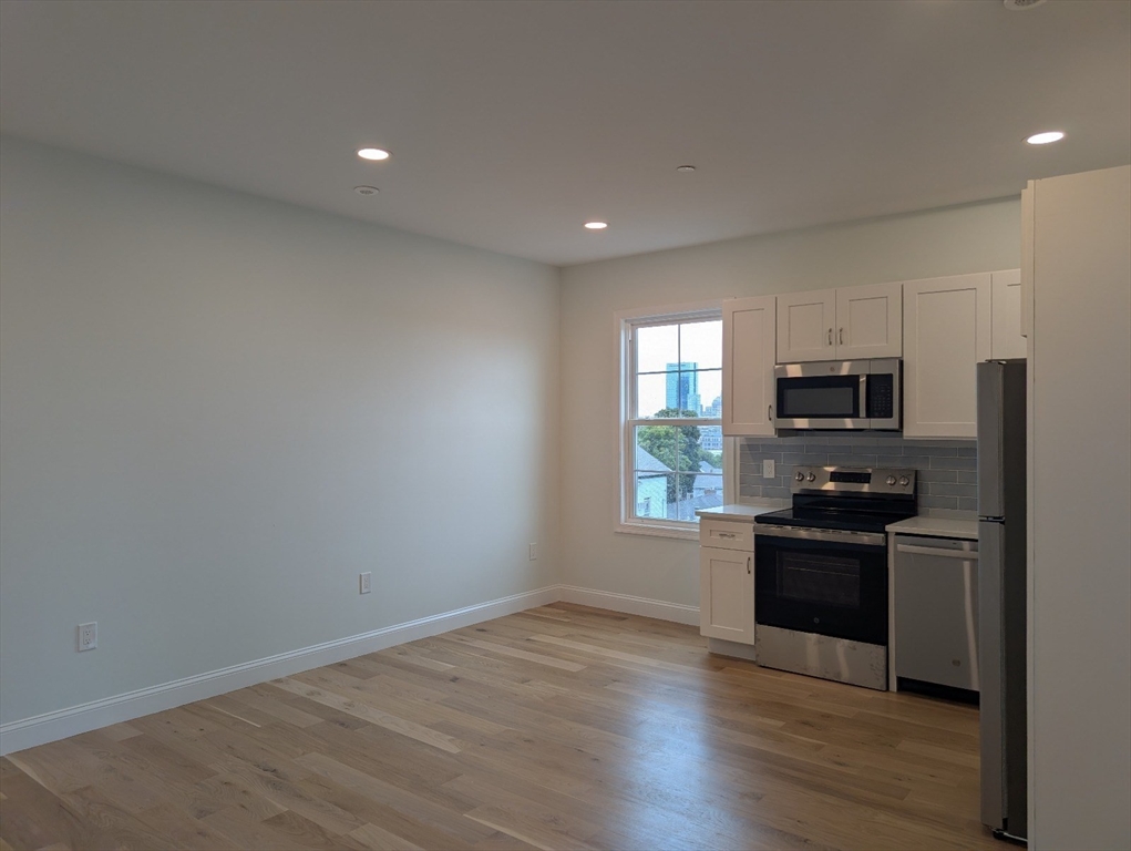 36 Regent Street, Unit 1 Boston, MA 02119 - Photo 2 of 12 a kitchen with granite countertop a stove top oven and sink