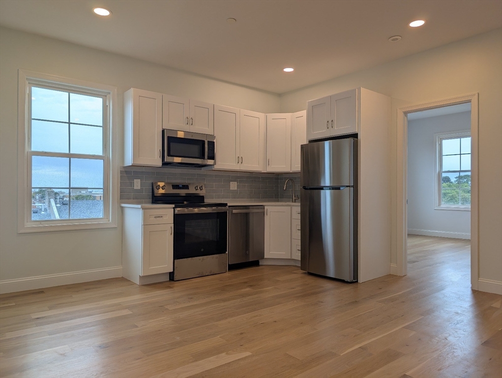 36 Regent Street, Unit 1 Boston, MA 02119 - Photo 3 of 12 a kitchen with a refrigerator and a stove top oven