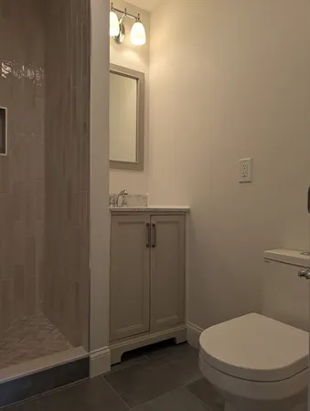 a bathroom with a toilet a sink and mirror