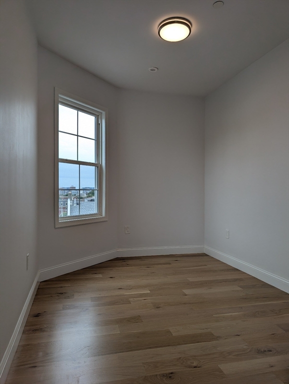 36 Regent Street, Unit 1 Boston, MA 02119 - Photo 10 of 12 an empty room with wooden floor and windows