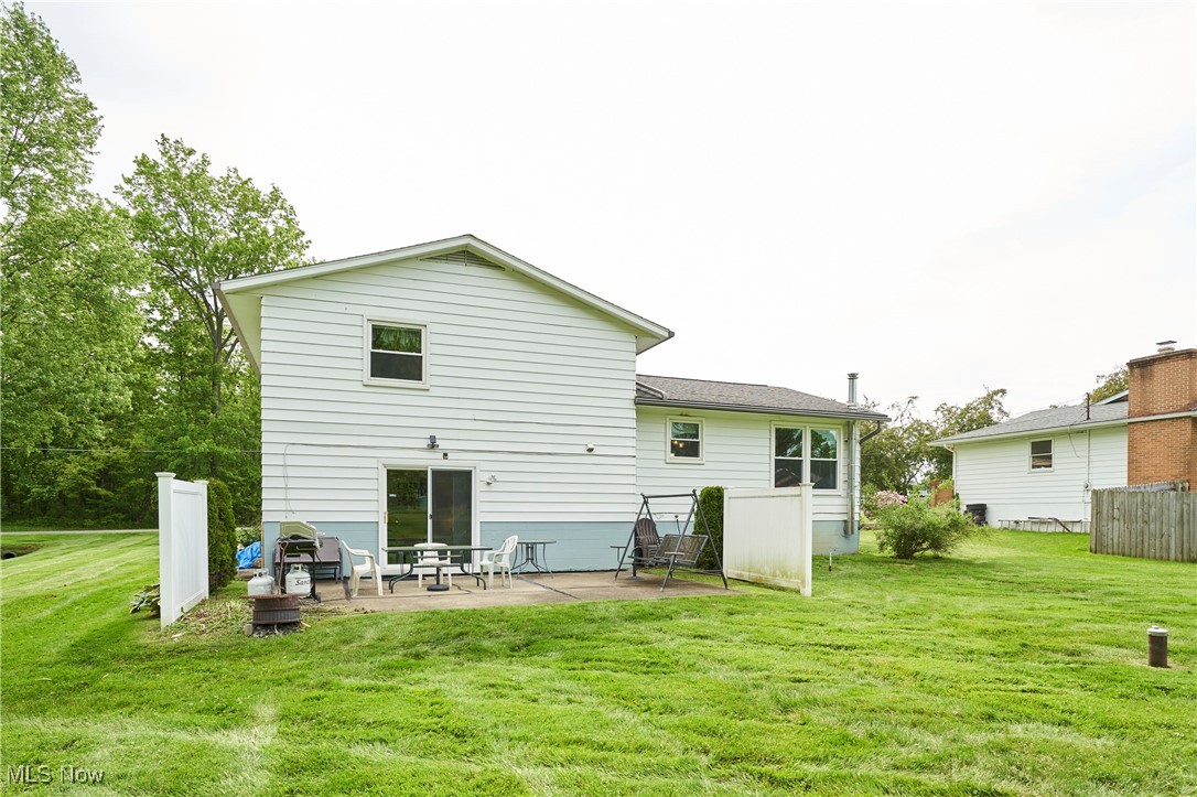 6214 Renninger Road Akron, OH 44319 - Photo 22 of 27 Back of house with a patio area and a lawn. This home is Brick and Aluminum sided
