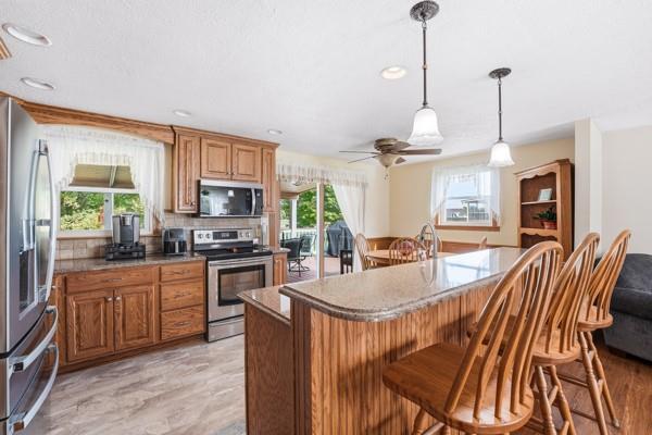19 Yankee Ridge Road Mercer, PA 16137 - Photo 13 of 42 a kitchen with stainless steel appliances granite countertop a stove top oven a sink dishwasher a dining table and chairs with wooden floor