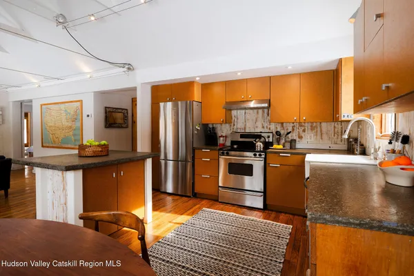 a kitchen with stainless steel appliances granite countertop sink refrigerator and microwave