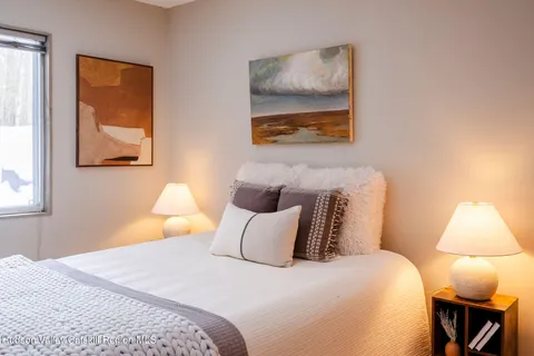 a bedroom with a bed and a painting on the wall