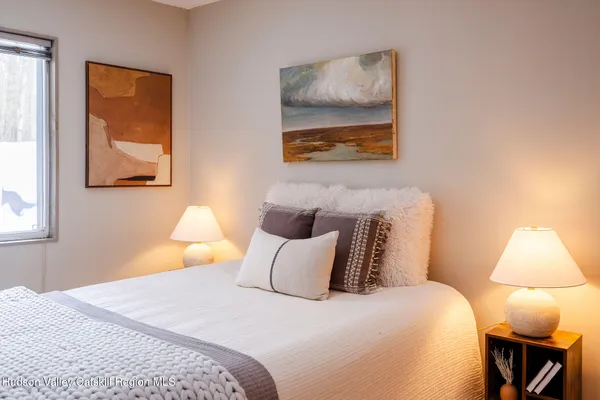 a bedroom with a bed and a painting on the wall