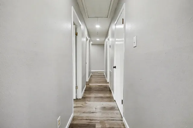 a view of a hallway with wooden floor