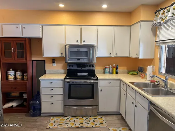 a kitchen with stainless steel appliances a stove a sink and a refrigerator