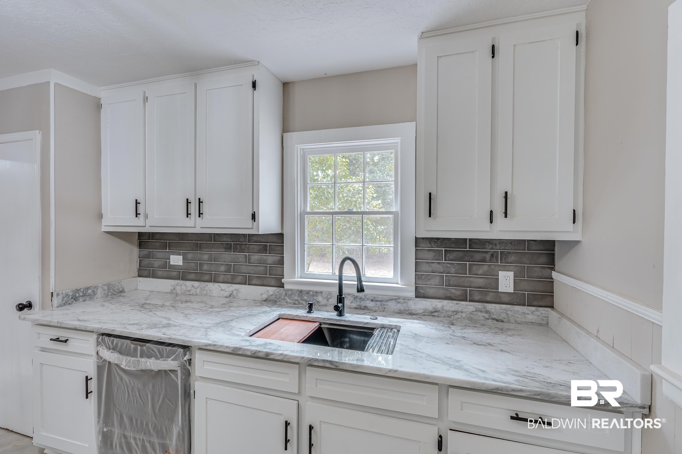 8001 16th Street Irvington, AL 36544 - Photo 12 of 35 Kitchen featuring tasteful backsplash and white cabinetry