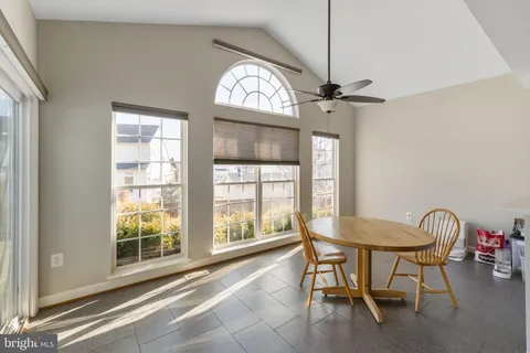 a dining room with furniture a chandelier and a window