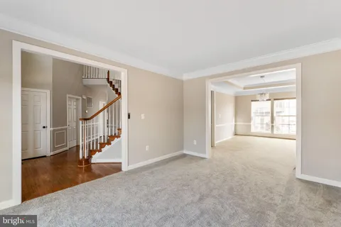 a view of an empty room with stairs and a window