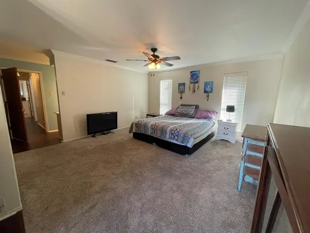 a spacious bedroom with a bed and a chandelier