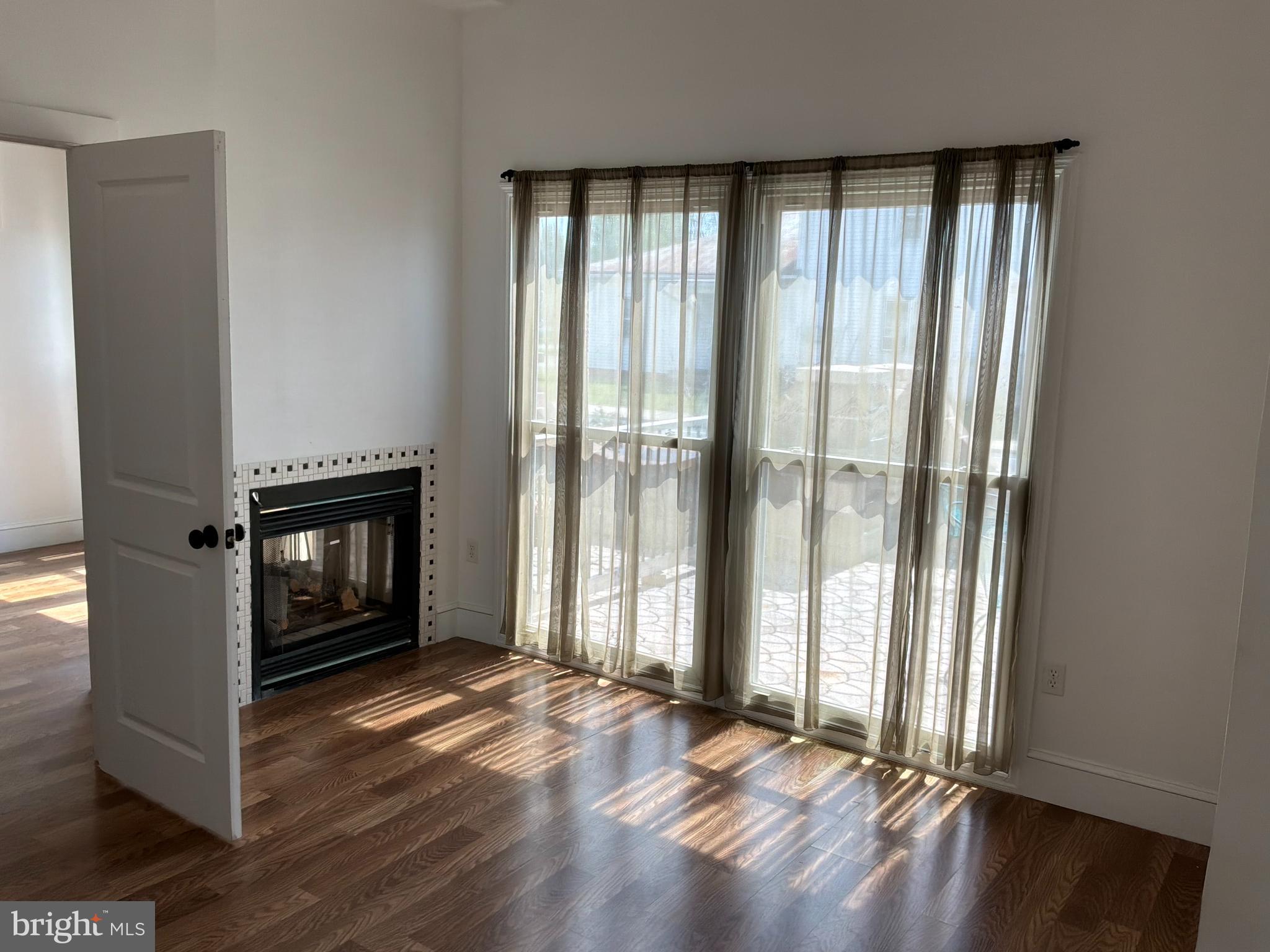 1359 Main Street, Unit B2 Woodside, DE 19904 - Photo 11 of 15 an empty room with wooden floor and windows