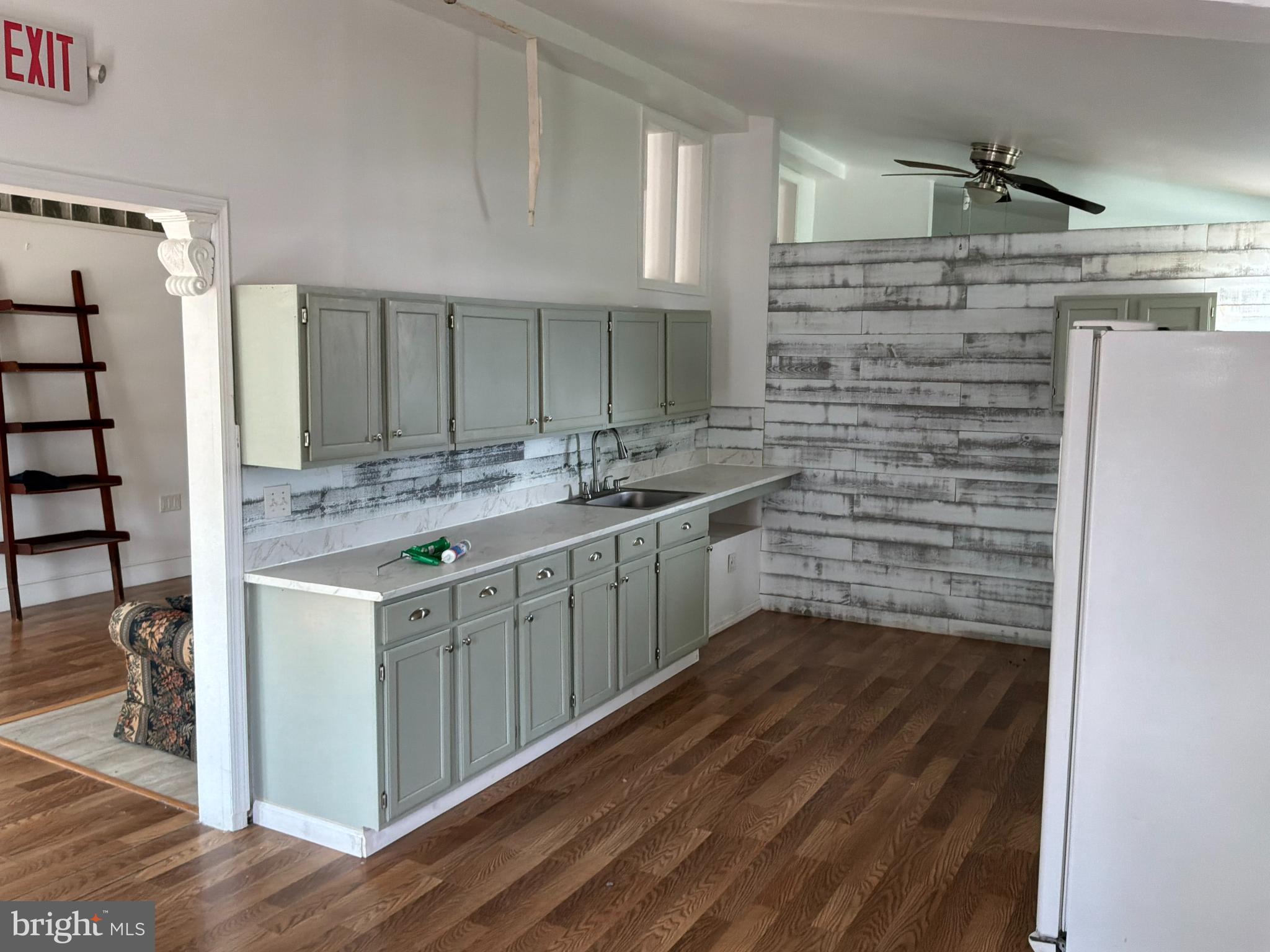 1359 Main Street, Unit B2 Woodside, DE 19904 - Photo 2 of 15 a kitchen with stainless steel appliances a sink cabinets and wooden floor