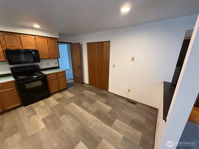a kitchen with granite countertop a refrigerator and a stove top oven