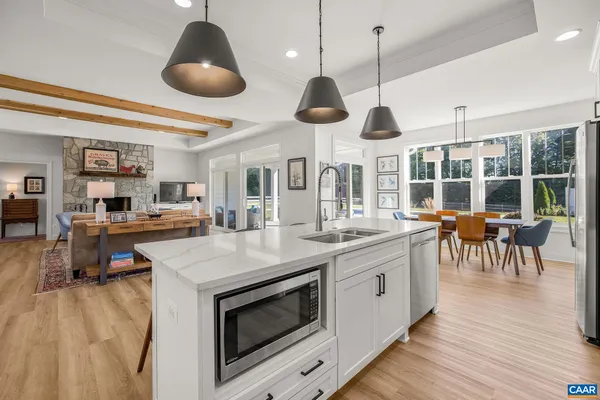 a large white kitchen with stainless steel appliances granite countertop a stove and a sink